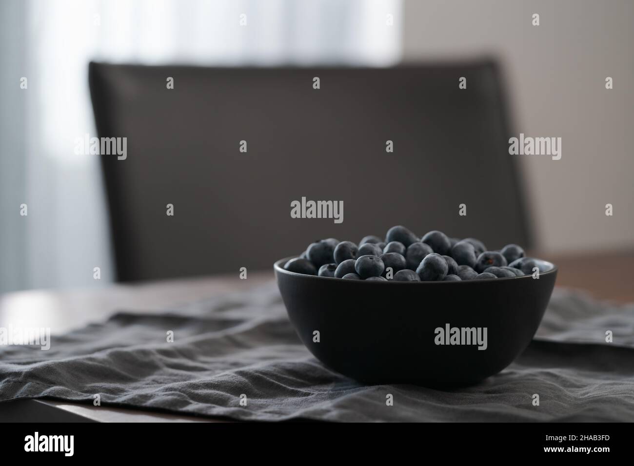 Große Schüssel mit Heidelbeeren auf dem Tisch, flacher Fokus Stockfoto