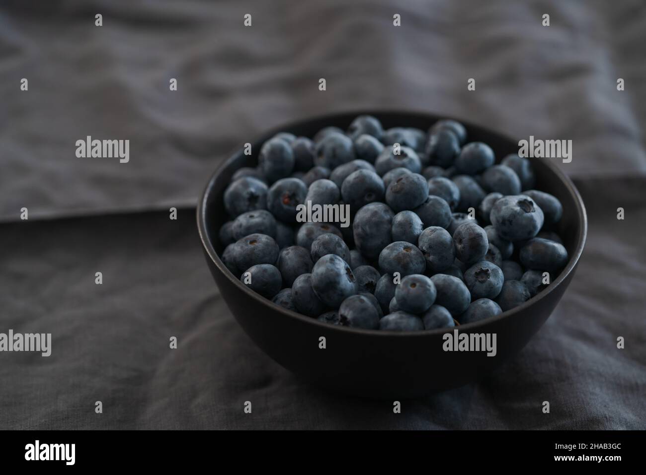 Große Schüssel mit Heidelbeeren auf dem Tisch, flacher Fokus Stockfoto