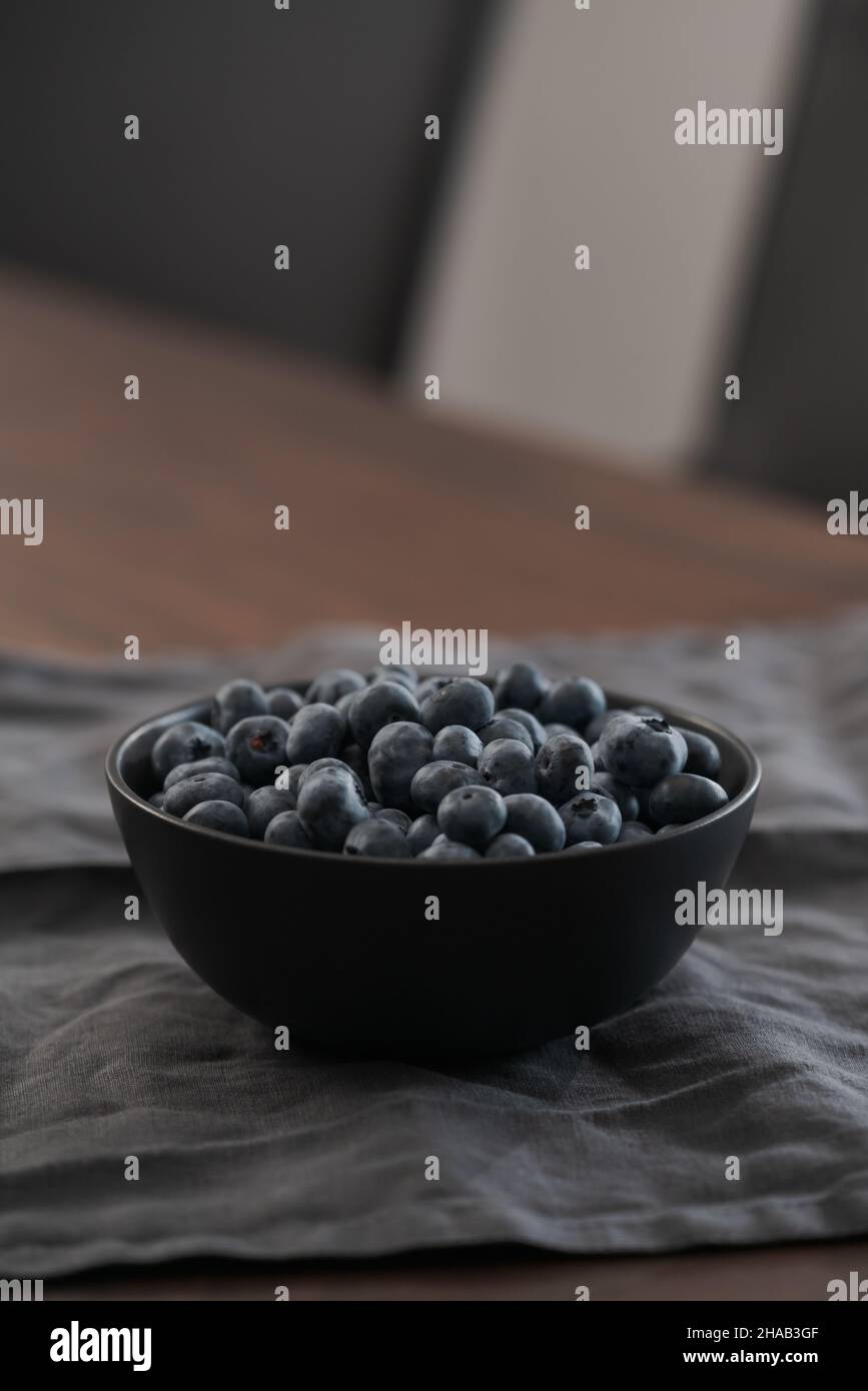 Große Schüssel mit Heidelbeeren auf dem Tisch, flacher Fokus Stockfoto