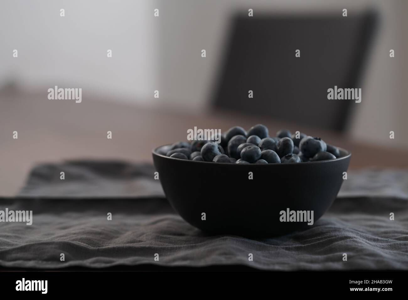 Große Schüssel mit Heidelbeeren auf dem Tisch, flacher Fokus Stockfoto