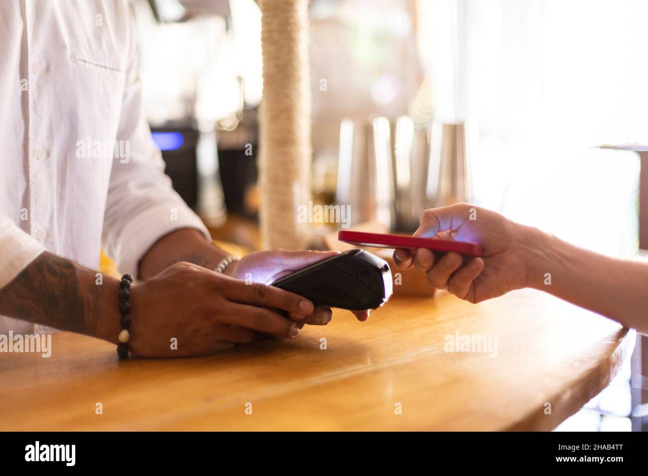 Nahaufnahme von zwei Personen, die eine kontaktlose Zahlung vornehmen. Platz für Text. Stockfoto