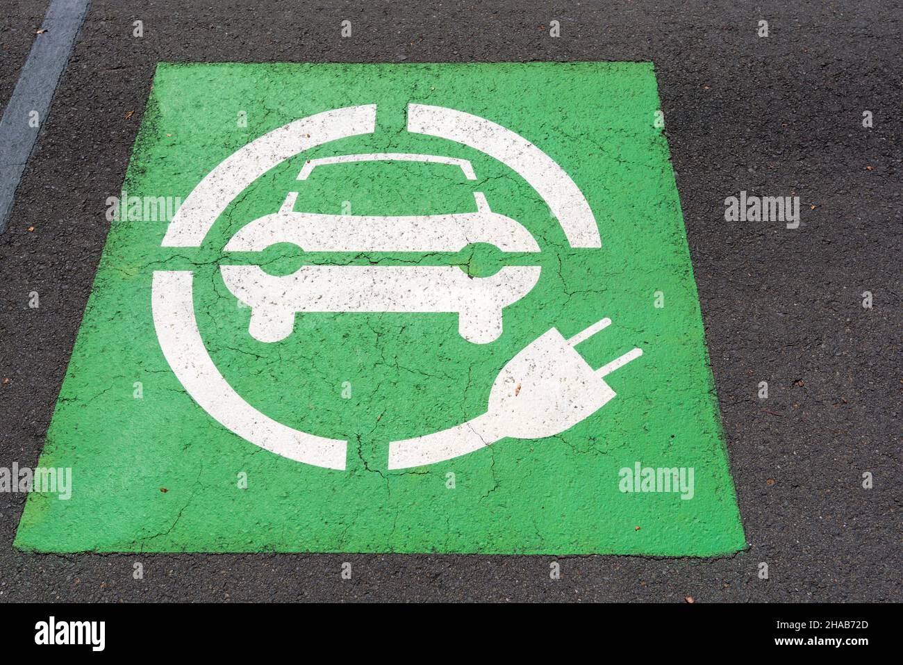 Ein grünes Symbol für die Elektrofahrzeug-Ladestelle für Elektrofahrzeuge auf Asphalt auf einem Parkplatz in Sydney, Australien Stockfoto