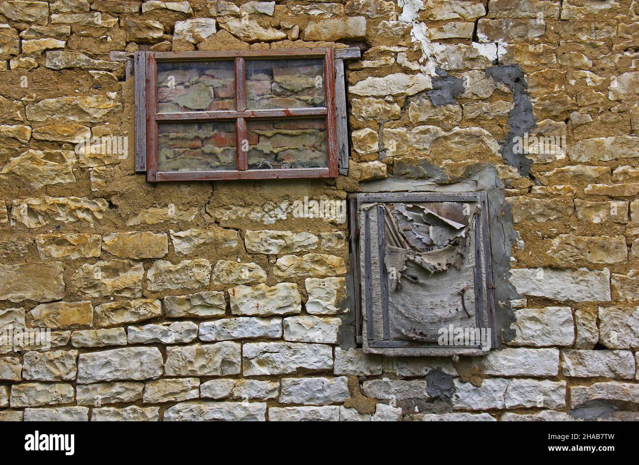 Zwei ummauerte alte Fenster in einer Steinmauer Stockfoto