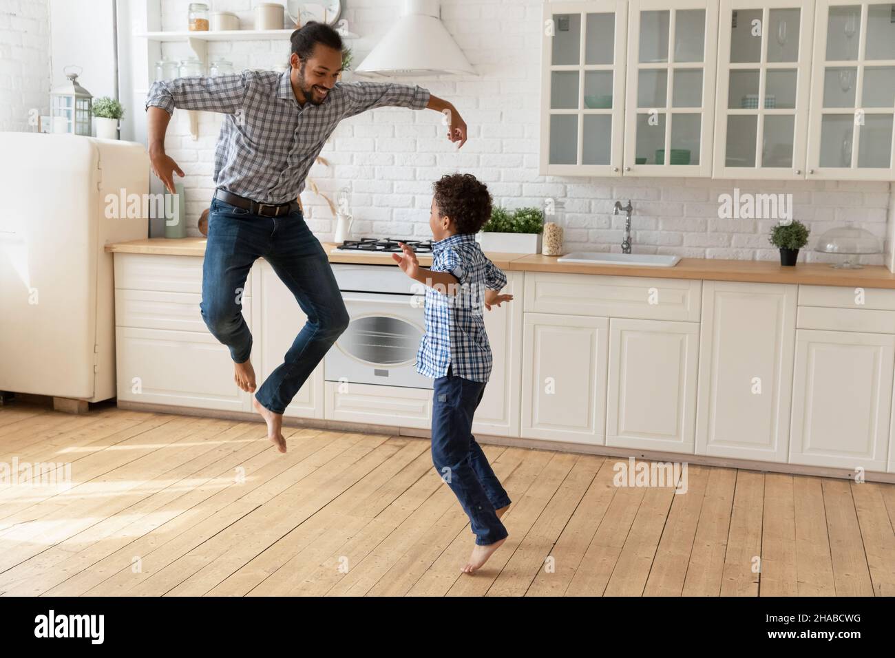 Afrikanischer Vater und kleiner Sohn springen Spaß in der Küche Stockfoto