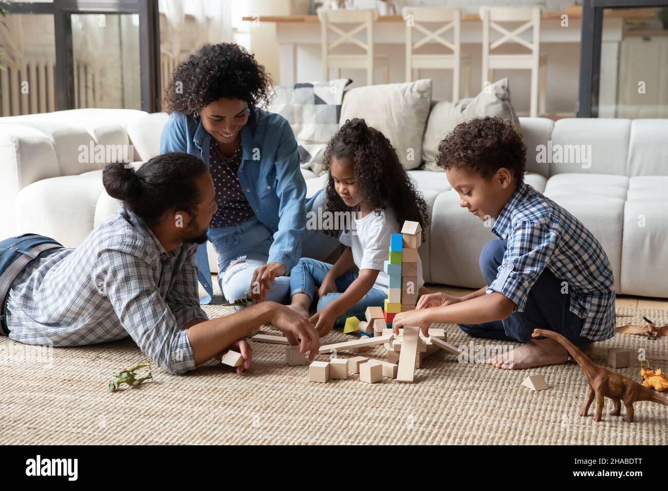 Afrikanische Kinder und Eltern spielen zu Hause Holzspielzeug zusammen Stockfoto