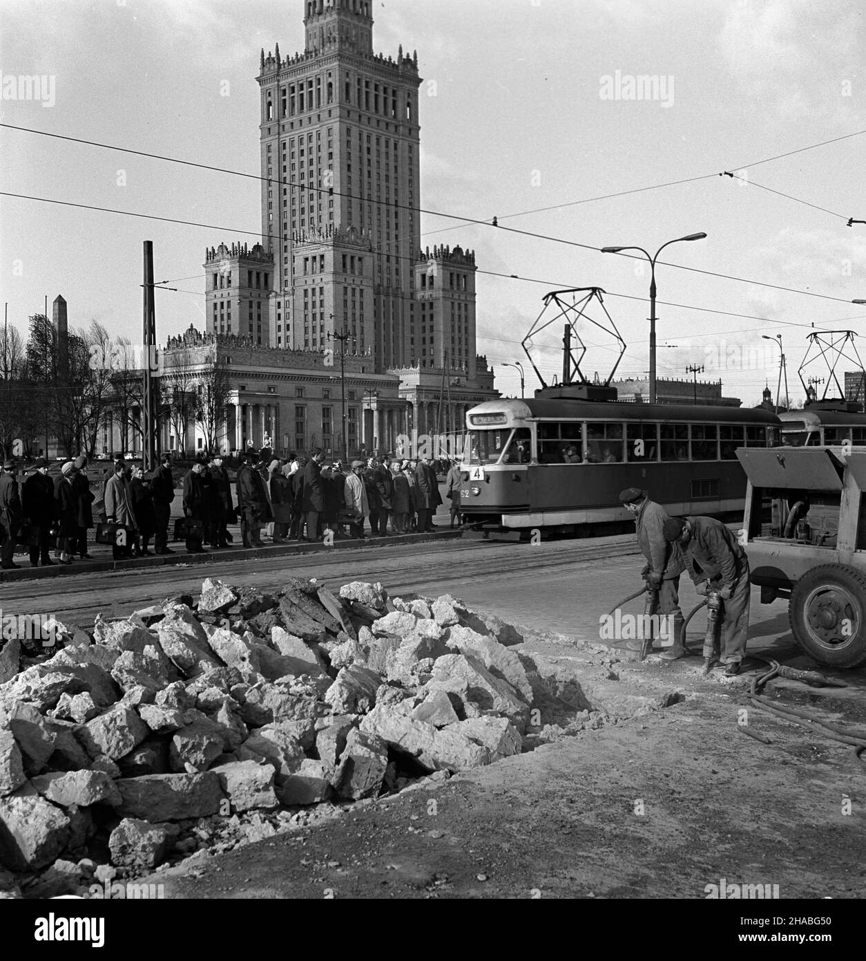 Warszawa, 1969-10. Przebudowa skrzy¿owania ulicy Marsza³kowskiej z Alejami Jerozolimskimi, jednego z najwiêkszych warszawskich skrzy¿owañ. NZ. Robotnicy usuwaj¹ star¹ nawierzchniê w pobli¿U przystanzu tramawjowego na ulicy Marsza³kowskiej. W oddali Pa³ac Kultury i Nauki (PKiN). Ad PAP/Adam Urbanek Dok³adny dzieñ wydarzenia nieustalony. Warschau, Oktober 1969. Wiederaufbau der Kreuzung der Straßen Marszalkowska und Jerozolimskie, einer der größten Kreuzungen in Warschau. Im Bild: Arbeiter entfernen alte Pflastersteine in der Nähe einer Straßenbahnhaltestelle in der Marszalkowska-Straße. Im Hintergrund der Palast der Kultur nad Stockfoto