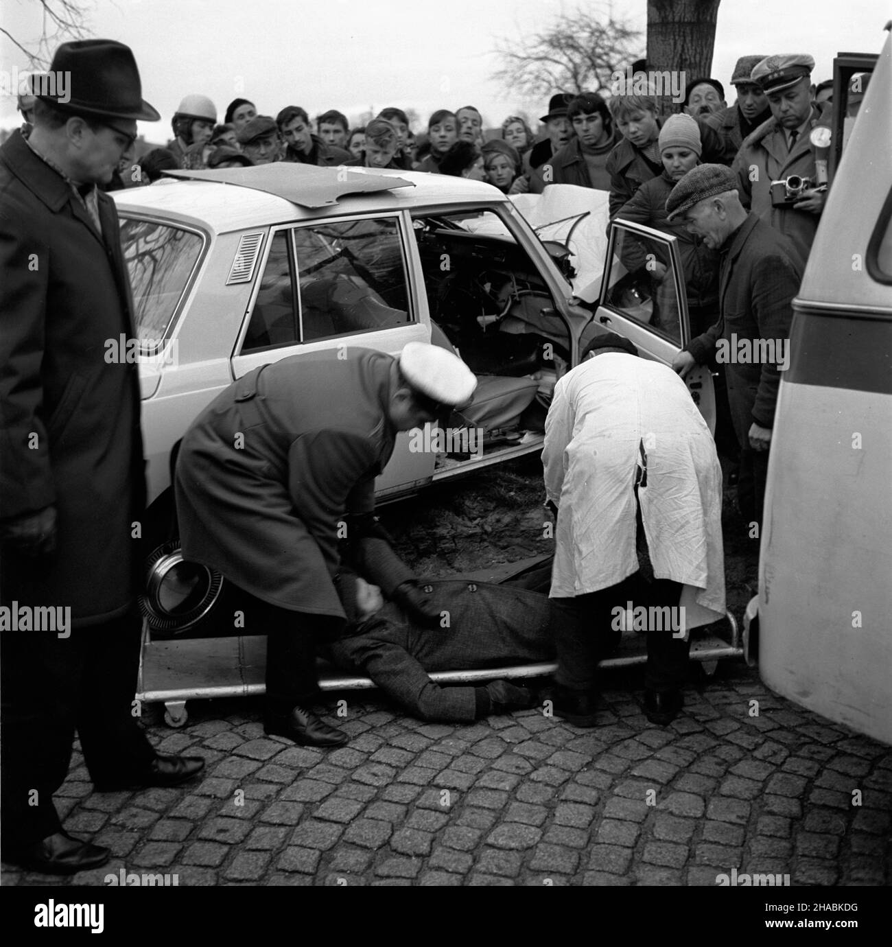 £ódŸ, 1969-11. Samochód marki Wartburg z nieustalonych przyczyn skrêci³ na lew¹ stronê jezdni uderzaj¹c w przydro¿ne drzewo. Wypadek mia³ miejsce na ul. Strykowskiej przed posesj¹ nr 10. Prowadz¹cy pojazd Jan G³owacki zosta³ przewieziony do szpitala im. Jordana. Obie Pasa¿erki Janina Œwiderek i Marianna Mirowska zmar³y. NZ. Wrak samochodu z ofiar¹ œmierteln¹ wypadku Janin¹ Œwiderek w czasie oglêdzin prowadzonych przez funkcjonariusza MO i sanitariusza. uu PAP/Witold Rozmys³owicz Dok³adny dzieñ wydarzenia nieustalony. Lodz, November 1969. Eine Wartburg ohne ermittelten Grund wandte sich an Th Stockfoto