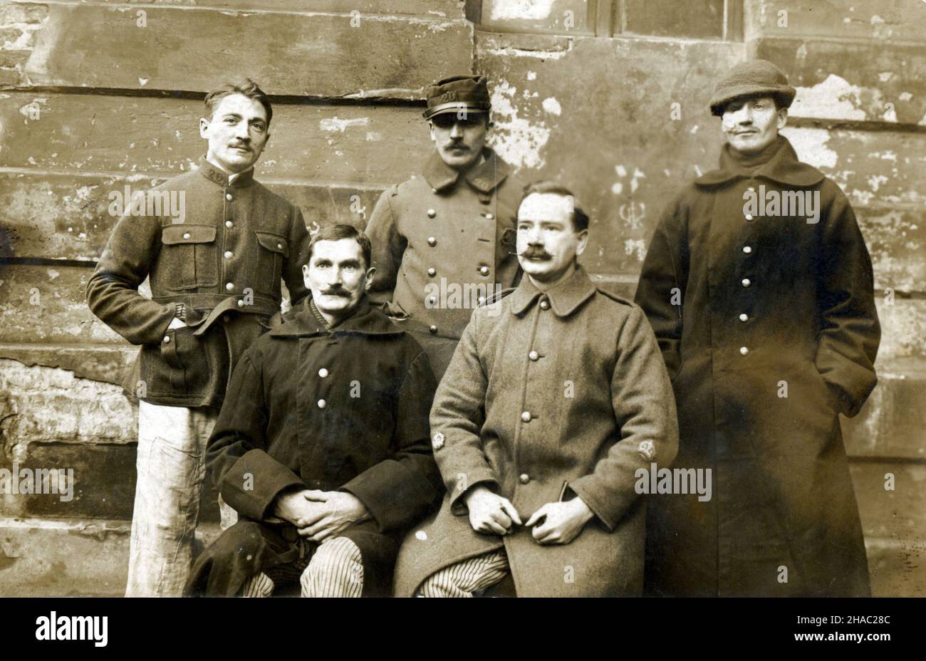 22nd. Dezember 1915. Deutsche Postkarte mit einer Gruppe von fünf französischen und britischen Kriegsgefangenen. Die Karte wurde vom Kriegsgefangenenlager in der Alexandrinenstraße in Berlin über London an die Eltern von Joshua.McCullough (2nd Royal Inniskilling Fusiliers) in Belfast geschickt. Er hat einen Hut nach unten gezogen, um eine Gesichtsverletzung zu verbergen. Der französische Offizier und Privatmann tragen farbenfrohe 1914 Uniformen. Stockfoto