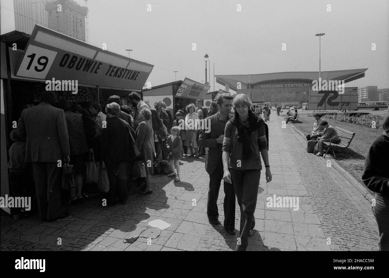 Warszawa, 1979-07-12. Kiermasz sprzêtu turystyczno-sportowego przed Pa³acem Kultury i Nauki (PKiN). NZ. Kolejka przed pawilonem z obuwiem tekstylnym. W tle Dworzec Centralny. Ad/gr PAP/Wojciech Frelek Warschau, 12. Juli 1979. Eine Messe der touristischen Ausrüstung vor dem Palast der Kultur und Wissenschaften. Im Bild: Menschen, die sich mit Kinderkleidung vor dem Pavillon aufmachen. Im Hintergrund der Hauptbahnhof. Ad/gr PAP/Wojciech Frelek Stockfoto