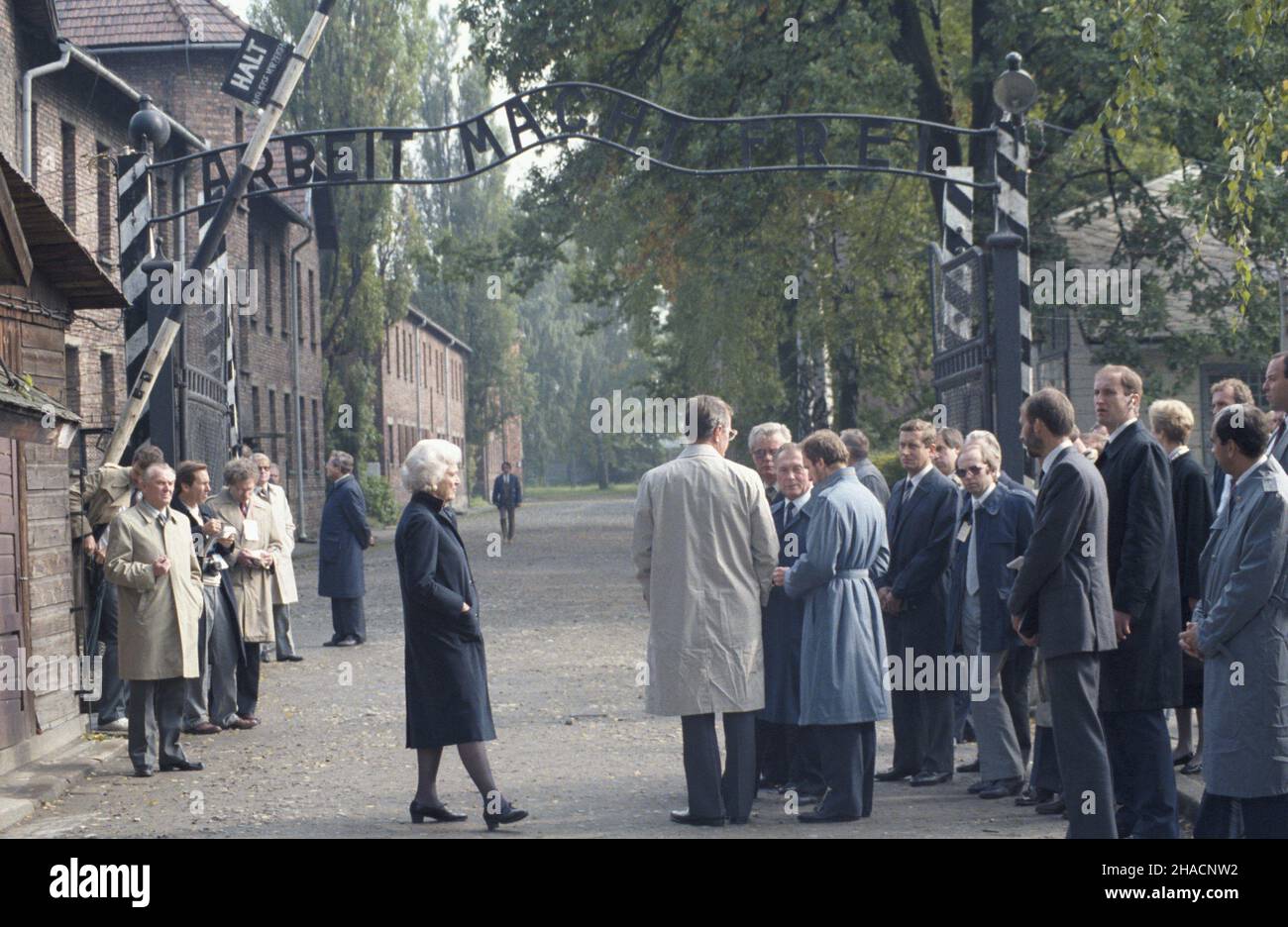 Oœwiêcim 29.09.1987. Wizyta wiceprezydenta Stanów Zjednoczonych George'a Busha z ma³¿onk¹ Barbar¹ w Polsce. Zwiedzanie niemieckiego nazistowskiego obozu konzentracyjnego i zag³ady (1940-1945), Auschwitz-Birkenau. NZ. Przed bram¹ do Auschwitz z napisem: Arbeit macht frei, zentralnie: Barbara Bush, George Bush, szef protoko³u dyplomatycznego Roman czy¿ycki, g³ówny twórca i dyrektor Pañstwowego Muzeum Auschwitz-Birkenau w Oœwiêcimiu Kazimierz Smoleñ. uu PAP/Jerzy Ochoñski Oswiecim 29. September 1987. US-Vizepräsident George Bush und seine Frau Barbara, die Polen besucht haben. Besuch der G Stockfoto