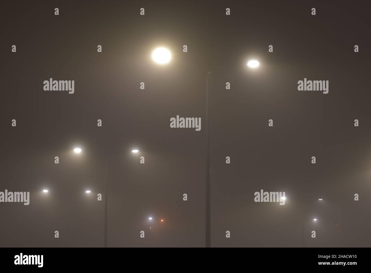 Nebel in der Stadt am Abend durch Straßenlaternen beleuchtet. Nacht. Stockfoto