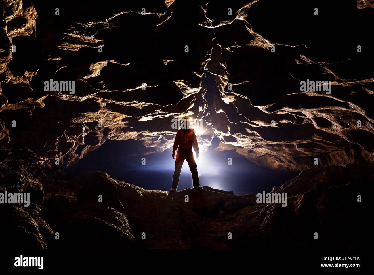 Höhlenforscher in einer Höhle in den Strahlen des Lichts Stockfoto