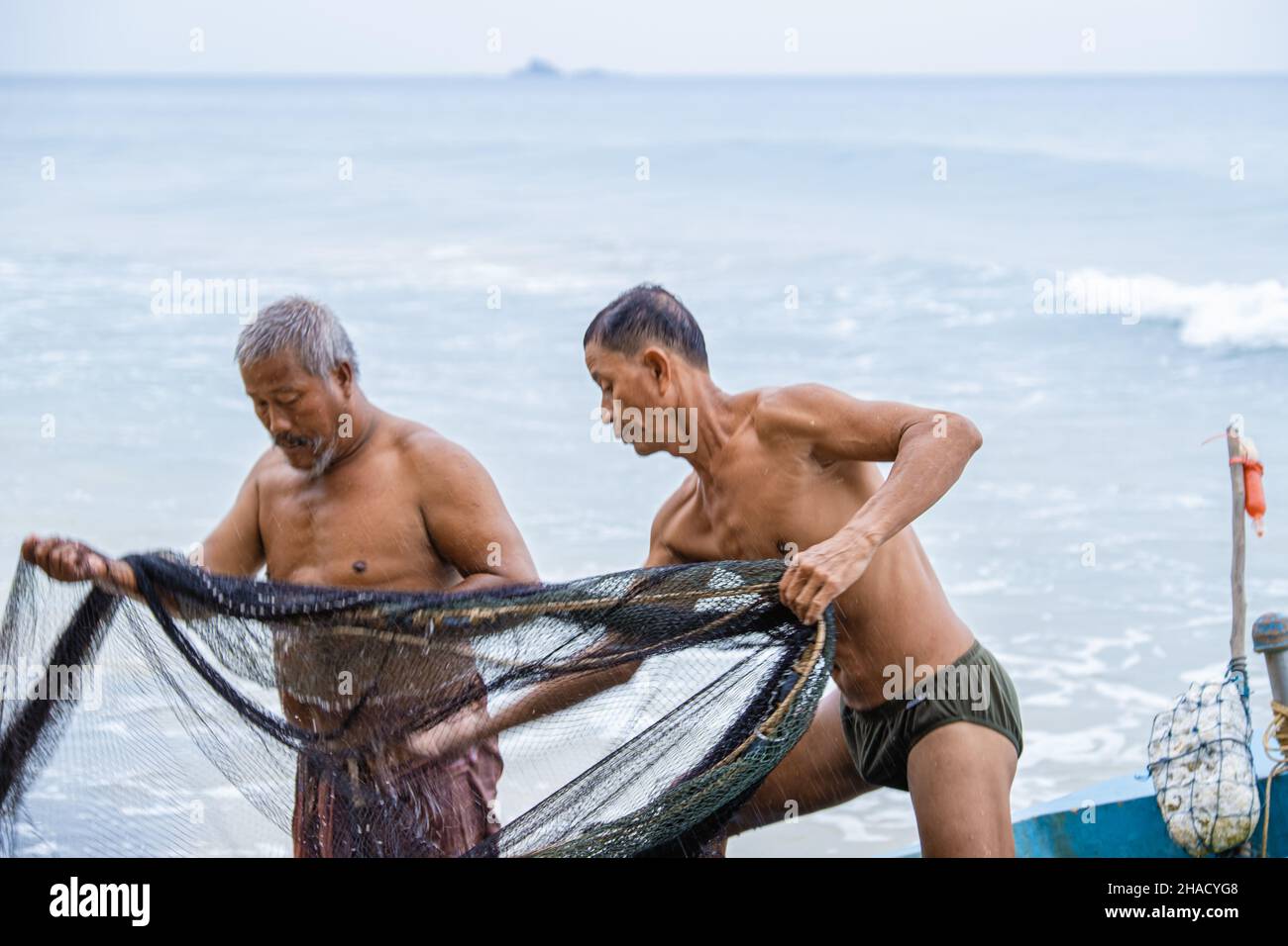 Phuket Thailand 2021. Dezember, der einheimische Fischer am Strand von Naithonbury entleeren ihre Fischernetze, der thailändische Fischer am Strand. Stockfoto