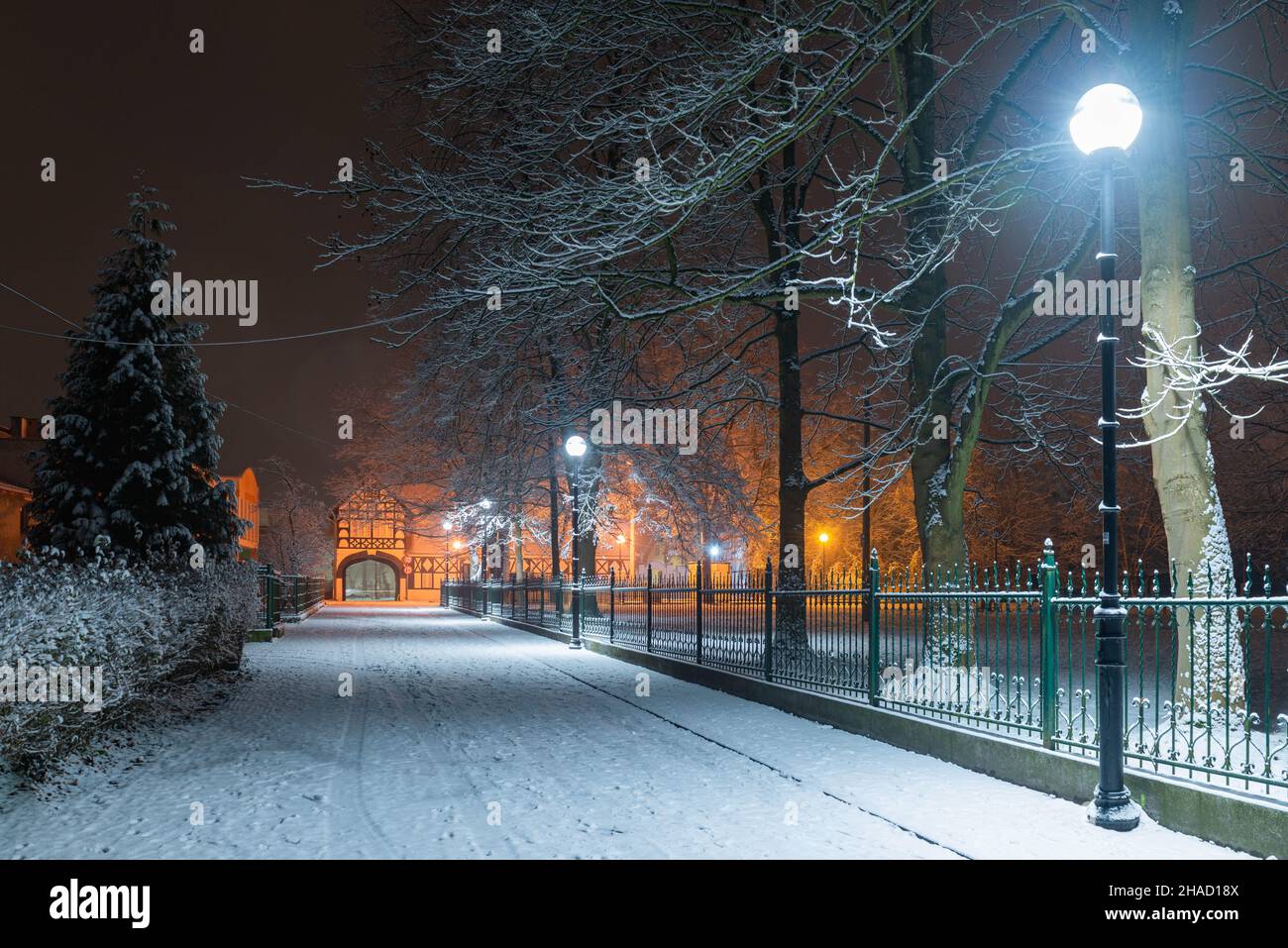 Eine Provinzstadt in Polen an einem verschneiten Winterabend. Straße in einer kleinen Provinzstadt Ilowa in Polen. Stockfoto