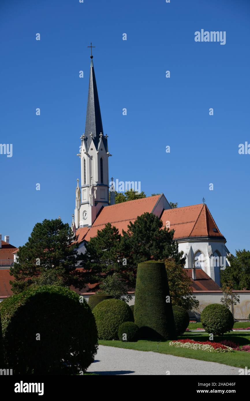 Ein gepflegter Park mit Büschen und einer Kirche im Hintergrund. Stockfoto