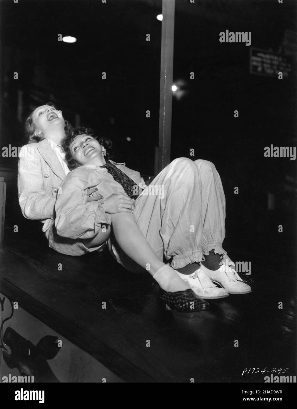 MARLENE DIETRICH und CLAUDETTE COLBERT auf der Rutsche auf der Venice Pier Fun House Party, die von Carole Lombard zu Ehren des A.C. veranstaltet wird Blumenthal und William Rhinelander Stewart im August 1935 Werbung für Paramount Picturs Stockfoto