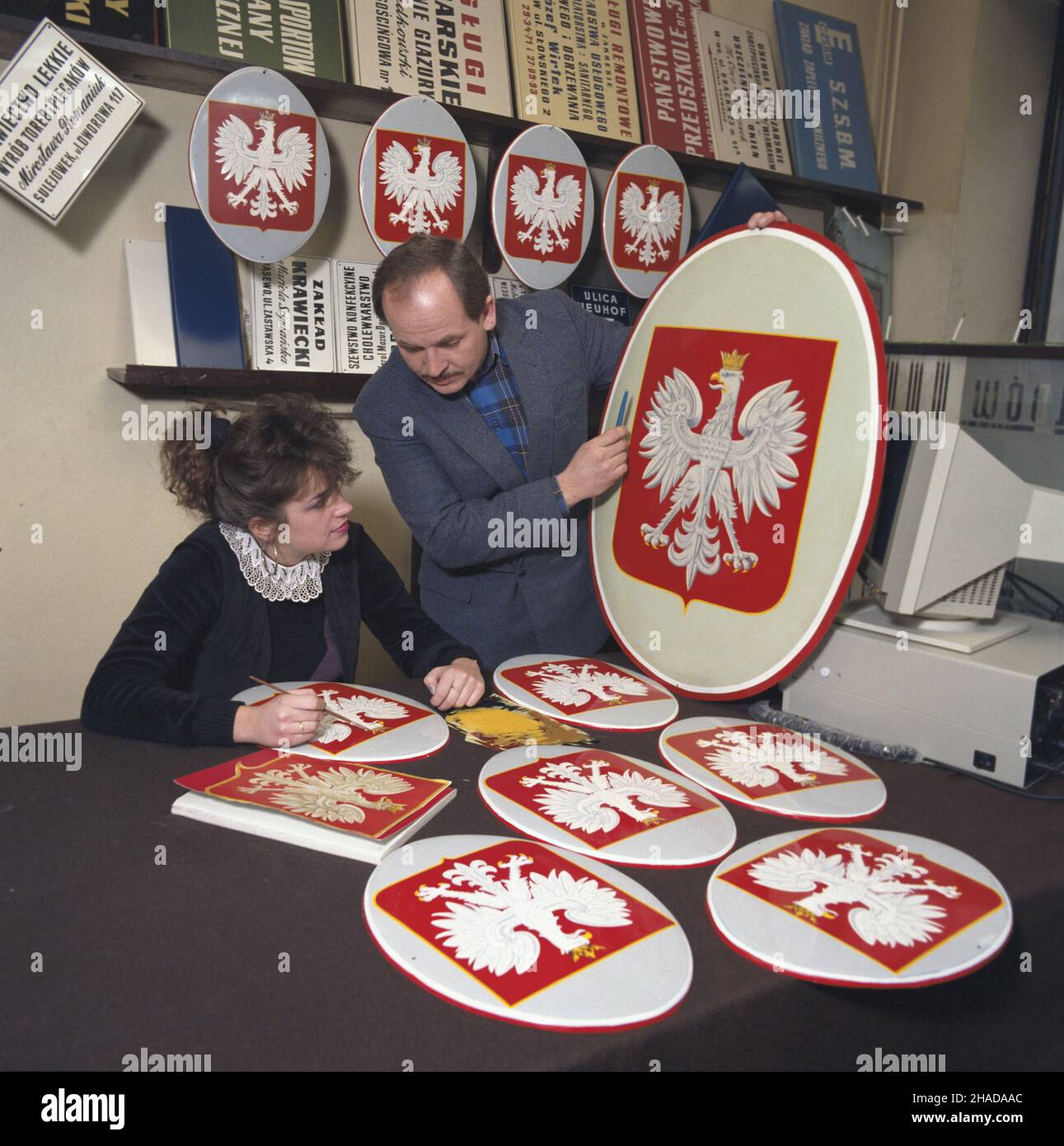Warszawa 01,1990. Zak³ad produkcji szyldów i tabvic. 31 grudnia 1989 r. wesz³a w ¿ycie zmiana konstytucji, która przywróci³a koronê w godle Polski. NZ. Domalowywanie korony na tablicach z or³em bia³ym po zmianie god³a pañstowego. wb PAP/Ireneusz Sobieszczuk Jan Bogacz Dok³adny dzieñ wydarzenia nieustalony. Warschau, Januar 1990. Hersteller von Schildern und Tablets. Am 31. Dezember 1989 wurde eine Verfassungsänderung zur Wiederherstellung der Krone im polnischen Staatswappen in Kraft gesetzt. Abgebildet: Bemalung der Krone auf den Tafeln mit dem weißen Adler nach dem Wechsel des nationalen Emblems. wb Stockfoto