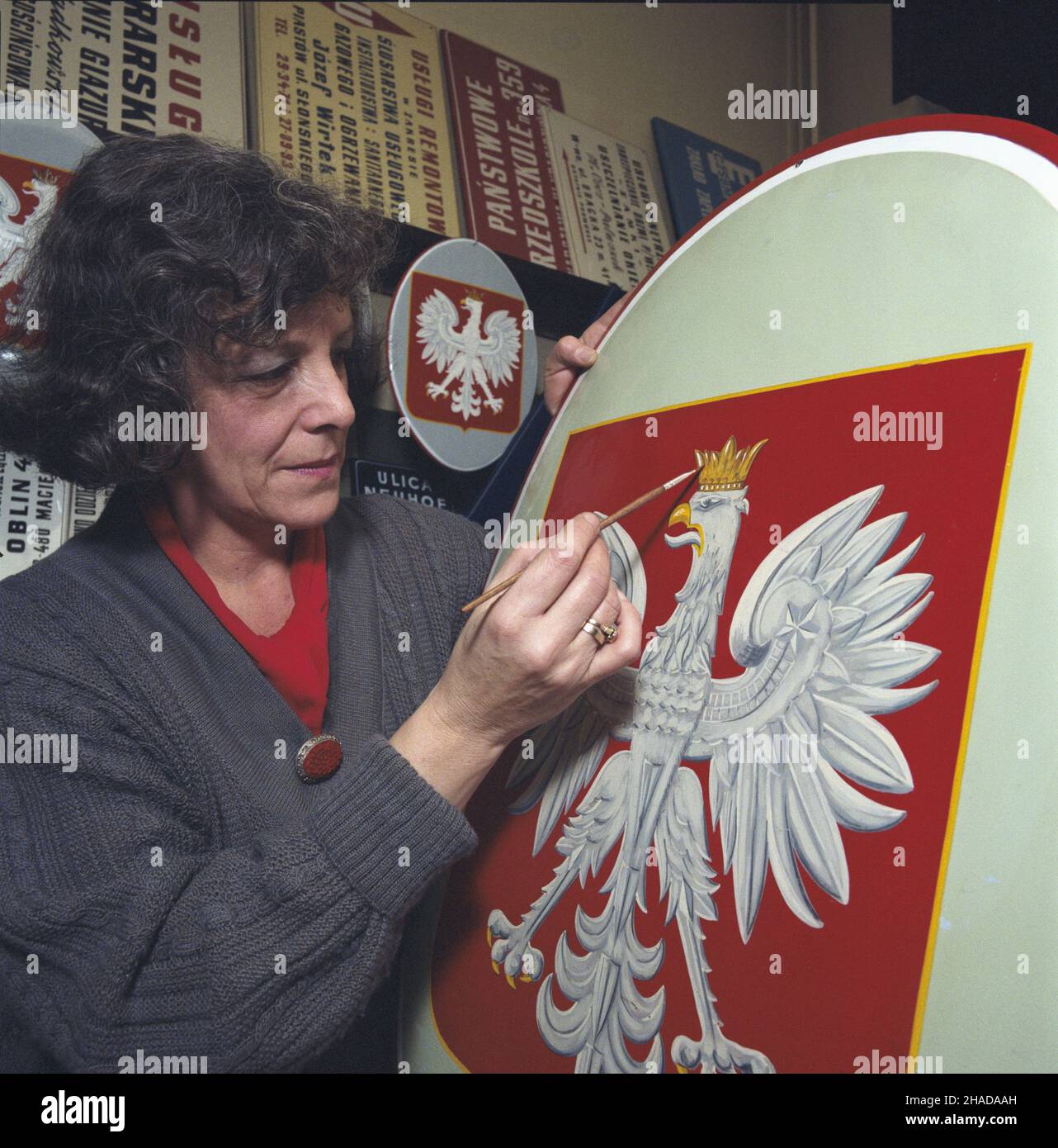 Warszawa 01,1990. Zak³ad produkcji szyldów i tabvic. 31 grudnia 1989 r. wesz³a w ¿ycie zmiana konstytucji, która przywróci³a koronê w godle Polski. NZ. Domalowywanie korony na tablicach z or³em bia³ym po zmianie god³a pañstowego. wb PAP/Ireneusz Sobieszczuk Jan Bogacz Dok³adny dzieñ wydarzenia nieustalony. Warschau, Januar 1990. Hersteller von Schildern und Tablets. Am 31. Dezember 1989 wurde eine Verfassungsänderung zur Wiederherstellung der Krone im polnischen Staatswappen in Kraft gesetzt. Abgebildet: Bemalung der Krone auf den Tafeln mit dem weißen Adler nach dem Wechsel des nationalen Emblems. wb Stockfoto