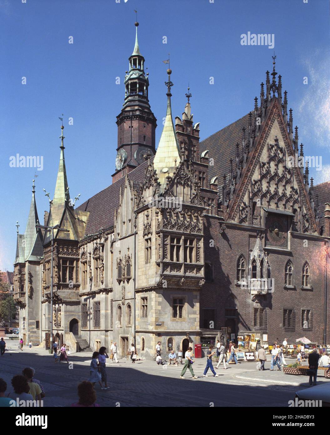 Wroc³aw 08,1990. PóŸnogotycki Ratusz, jego budowa trwa³a od po³owy XII wieku po wiek XVI. Na 67 metrowej wie¿y, zwieñczonej renesansowym he³mem jest najstarszy w Polsce dzwon zegarowy z 1368 r. Z prawej widoczna wschodnia strona budynku, bogato zdobiony szczyt ze sterczdynamii i zegarem œredniowiecznym. mw PAP/Jan Morek Dok³adny dzieñ wydarzenia nieustalony. Breslau, August 1990. Das spätgotische Rathaus, erbaut von der Mitte des 12th. Jahrhunderts bis zum 16th. Jahrhundert. Ein 67 Meter hoher Turm mit der ältesten Glocke Polens aus dem Jahr 1368. mw PAP/Jan Morek Veranstaltungstag unbekannt Stockfoto