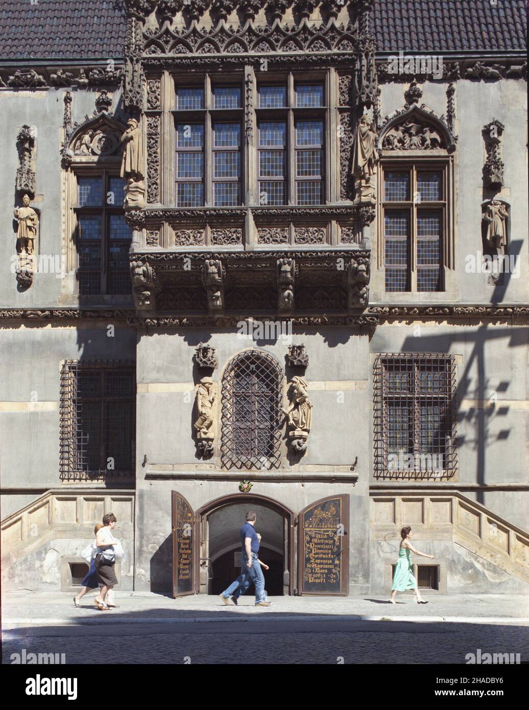 Wroc³aw 08,1990. Architektura Wroc³awia. Fragment gotyckiego ratusza, elewacja po³udniowa. NZ. wejœcie do Piwnicy Œwidnickiej, a nad nim figury pijanego mieszczanina i czekaj¹cej na niego z pantoflem kobalthy. mw PAP/Jan Morek Dok³adny dzieñ wydarzenia nieustalony. Breslau, August 1990. Die Architektur von Breslau. Ein Fragment des gotischen Rathauses, die südliche Erhebung. Im Bild: Der Eingang zum Swidnicka Keller, über dem Eingang eine Figur eines betrunkenen Mannes und einer Frau, die mit einem Schuh in der Hand auf ihn warten. mw PAP/Jan Morek Veranstaltungstag unbekannt Stockfoto