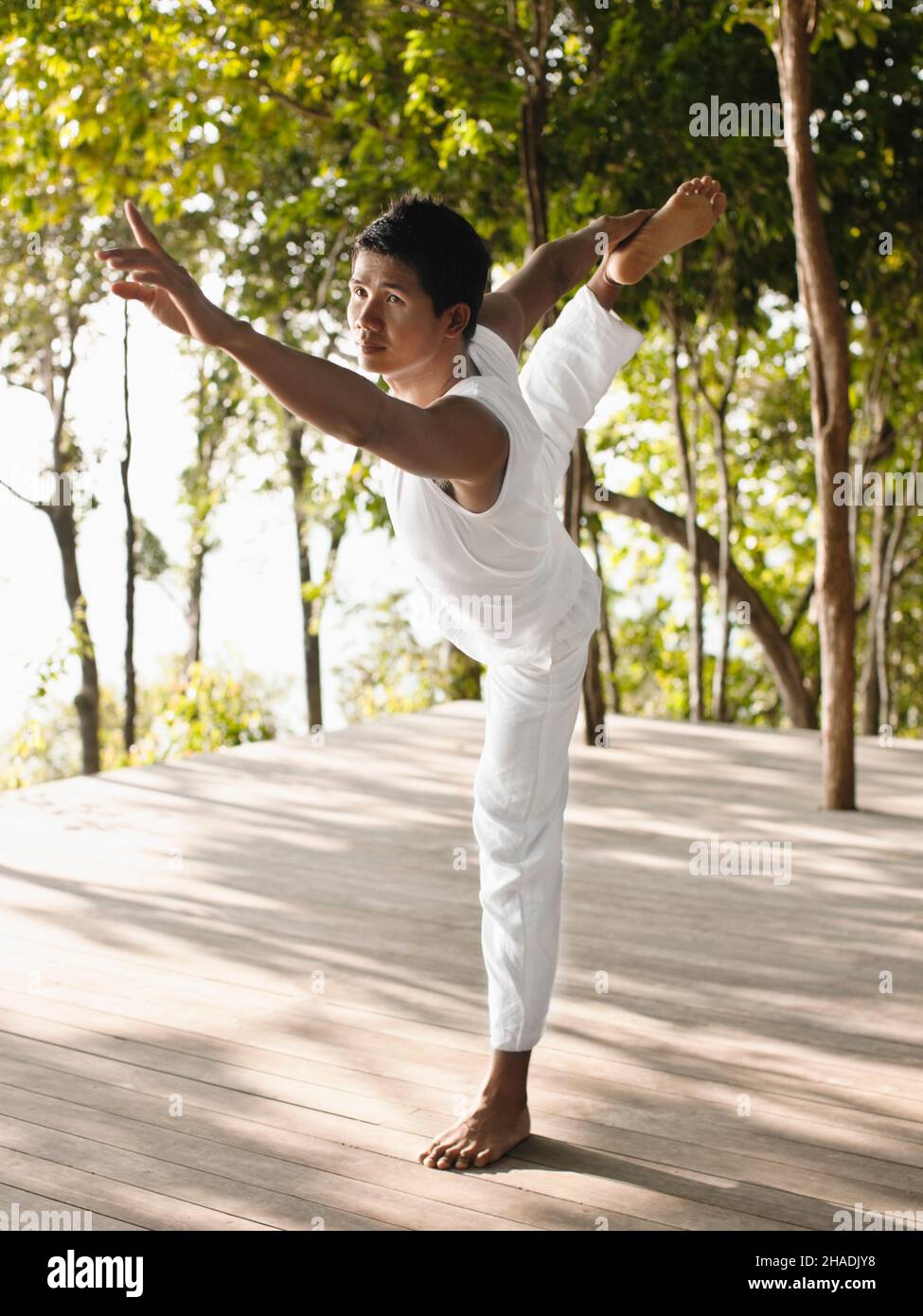 Ein Yogalehrer praktiziert Yoga auf der Baumwipfelplattform mit Blick auf die Phang Nga Bay im Six Senses Hideaway Yao Noi. Thailand. Stockfoto