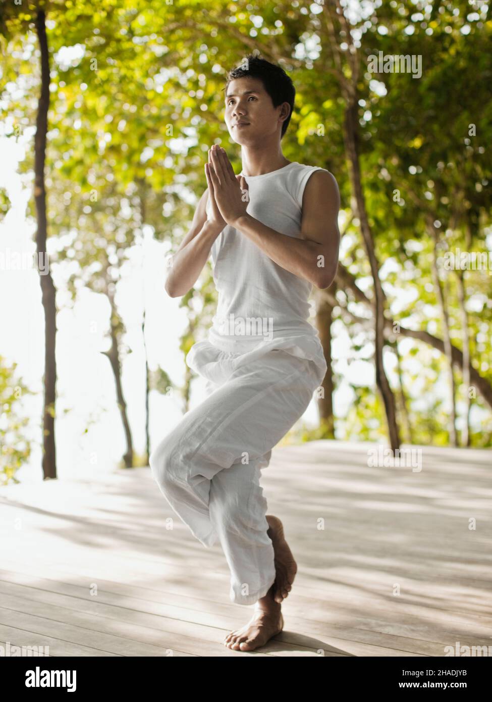 Ein Yogalehrer praktiziert Yoga auf der Baumwipfelplattform mit Blick auf die Phang Nga Bay im Six Senses Hideaway Yao Noi. Thailand. Stockfoto