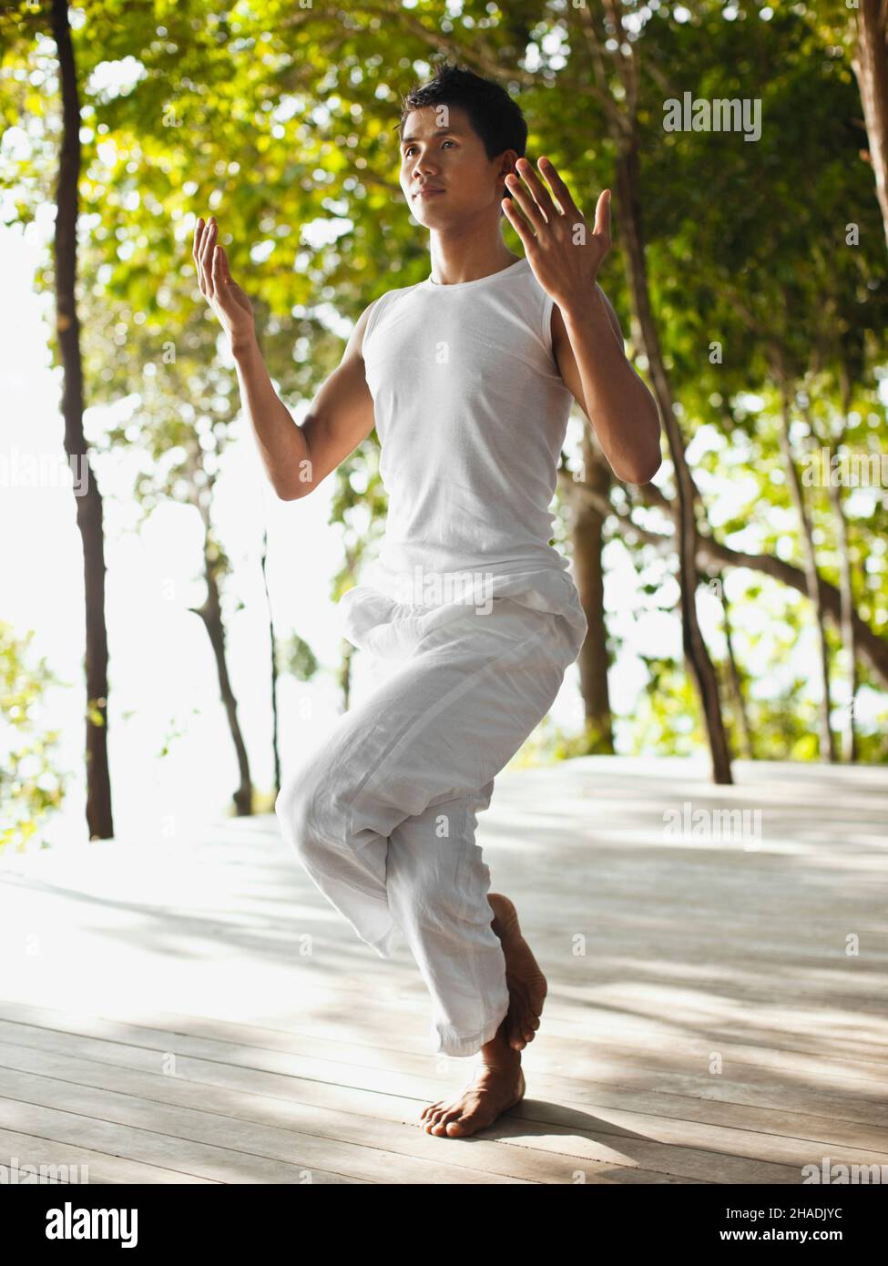 Ein Yogalehrer praktiziert Yoga auf der Baumwipfelplattform mit Blick auf die Phang Nga Bay im Six Senses Hideaway Yao Noi. Thailand. Stockfoto