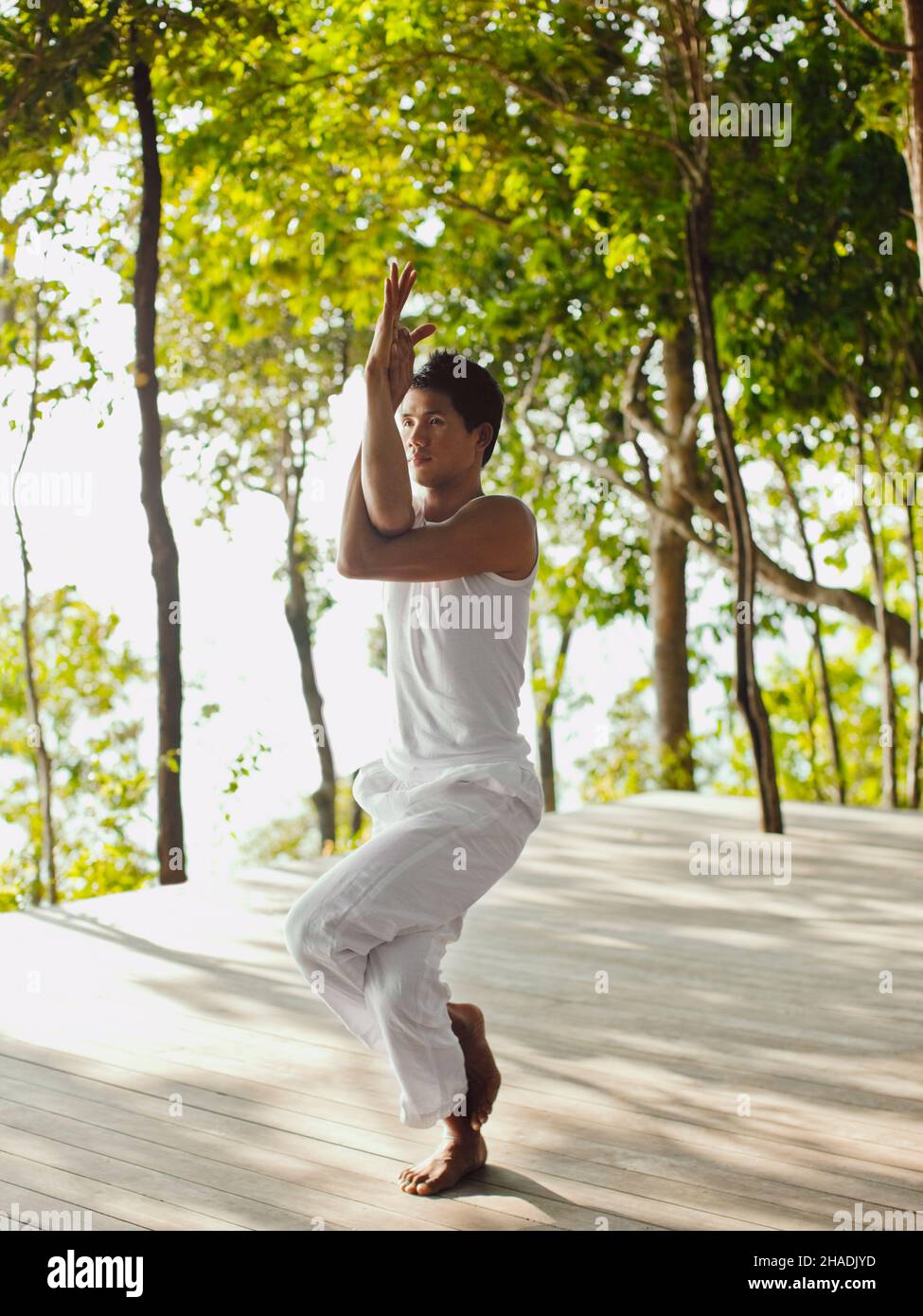 Ein Yogalehrer praktiziert Yoga auf der Baumwipfelplattform mit Blick auf die Phang Nga Bay im Six Senses Hideaway Yao Noi. Thailand. Stockfoto
