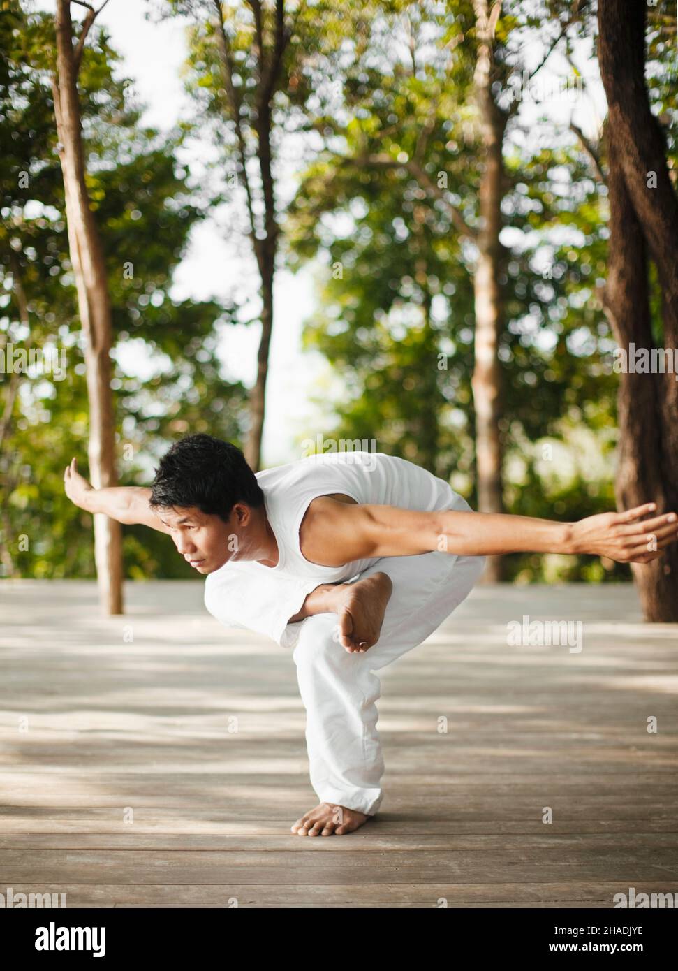Ein Yogalehrer praktiziert Yoga auf der Baumwipfelplattform mit Blick auf die Phang Nga Bay im Six Senses Hideaway Yao Noi. Thailand. Stockfoto