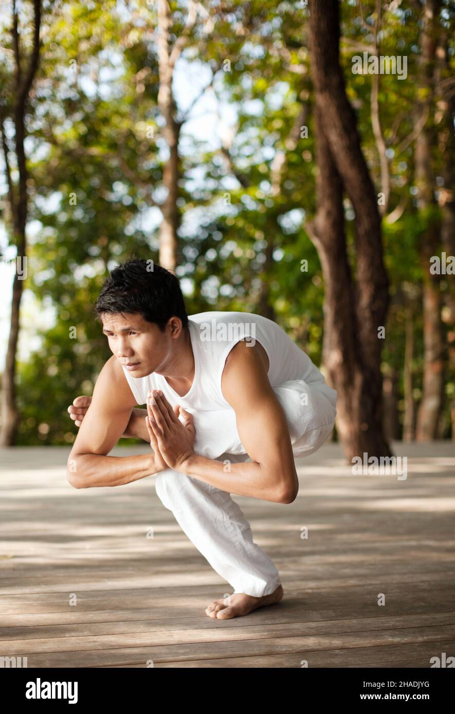 Ein Yogalehrer praktiziert Yoga auf der Baumwipfelplattform mit Blick auf die Phang Nga Bay im Six Senses Hideaway Yao Noi. Thailand. Stockfoto