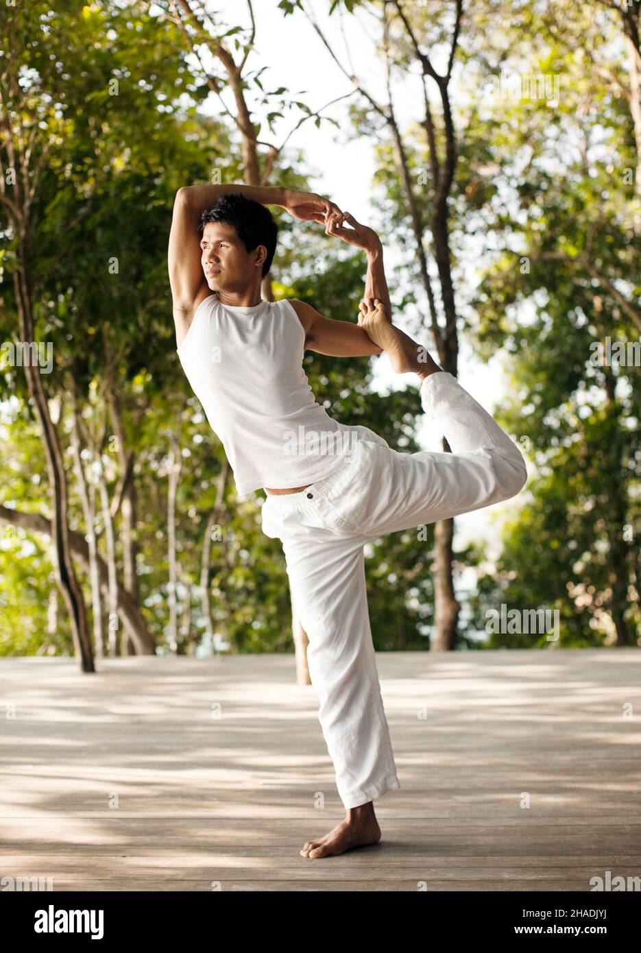 Ein Yogalehrer praktiziert Yoga auf der Baumwipfelplattform mit Blick auf die Phang Nga Bay im Six Senses Hideaway Yao Noi. Thailand. Stockfoto