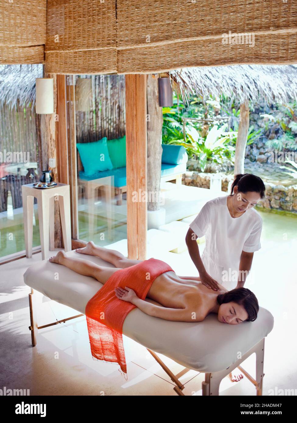 Eine Frau erhält eine Fusion-Massage im Six Senses Spa. Bei der Fusion Massage handelt es sich um eine 80-minütige Behandlung, bei der die schwedische, die thailändische und die Aromatherapie kombiniert werden Stockfoto