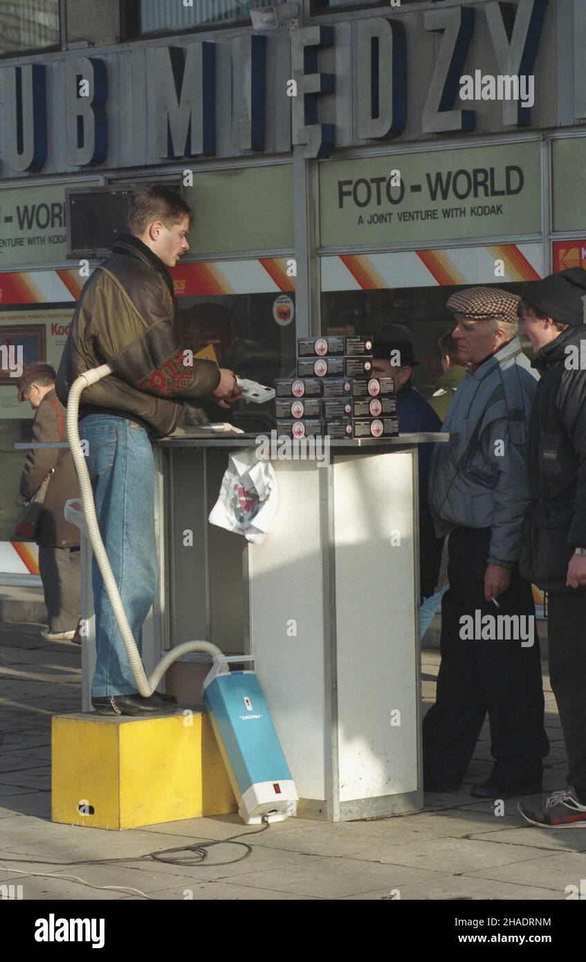 Warszawa 06.01.1994. Handel na warszawskiej ulicy, gdzie towar sprzedawany jest z przenoœnych stoisk, stolików i ³ó¿ek polowych ustawianych na chodnikach. NZ. Uliczne stoisko handlowe przed Domami Centrum na ul. Marsza³kowskiej (Œródmieœcie Pó³nocne). mta PAP/Andrzej Rybczyñski Warschau 06. Januar 1994. Straßenverkauf in Warschau; Waren werden von Klappständen, Tischen und Lagerbetten auf dem Bürgersteig verkauft. Im Bild: Verkaufsstand vor dem Kaufhaus Domy Centrum in der Marszalkowska Straße (Nordzentrum). mta PAP/Andrzej Rybczynski Stockfoto