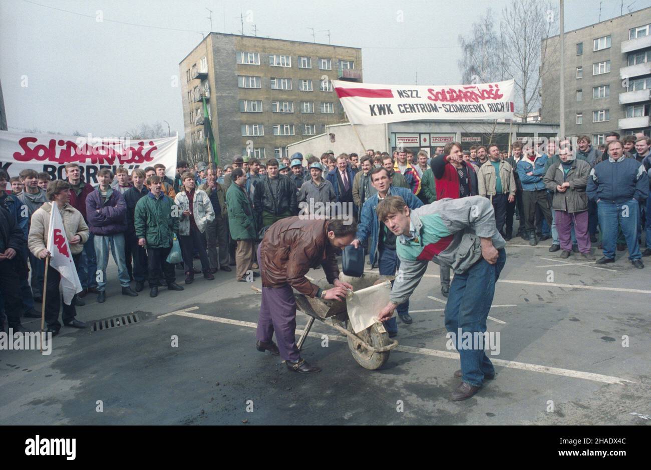 Radzionków 11.03.1994. Akcja protestacyjna przed budynkiem Bytomskiej Spó³ki Wêglowej, zorganizowana przez Niezale¿ny Samorz¹dny Zwi¹zek Zawodowy Solidarnoœæ (NSZZ Solidarnoœæ). Zwi¹zek domaga siê rekompensaty wzrostu kosztów utrzymania oraz przestrzegania ustaw Paktu o Przedsiêbiorstwie Pañstwowym. NZ. protestuj¹cy dla ¿artu wrzucali na taczki pieni¹dze na premiê dla dyrektora Spó³ki. js PAP/Stanis³aw Jakubowski Radzionkow 11. März 1994. Eine Protestaktion vor der Bytomska Coal Company, die von der unabhängigen und selbstständigen Gewerkschaft Solidarnosc (NSZZ Solidarnosc) organisiert wurde Stockfoto