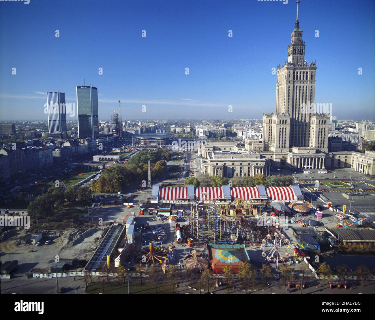 Warszawa 08,1994. Plac Defilad i Pa³ac Kultury i Nauki. Na pierwszym planie Weso³e Miasteczko Cricoland i hala targowa Marcpolu. Z lewej plac budowy stacji metra Centrum, zabudowania wzd³u¿ Alei Jerozolimskich i stacja kolejowa PKP Œródmieœcie. W g³êbi Hotel Mariott i dworzec Centralny. wb PAP/Piotr Gêsicki Dok³adny dzieñ wydarzenia nieustalony. Warschau, August 1994. Defilad Platz und der Palast der Kultur und Wissenschaft. Im Vordergrund Cricoland Kirmes und Marcpol Marktplatz. Von links die U-Bahn-Baustelle, Gebäude entlang Jerozolimskie Avenue und PKP Srodmiescie (Zentrum) r Stockfoto