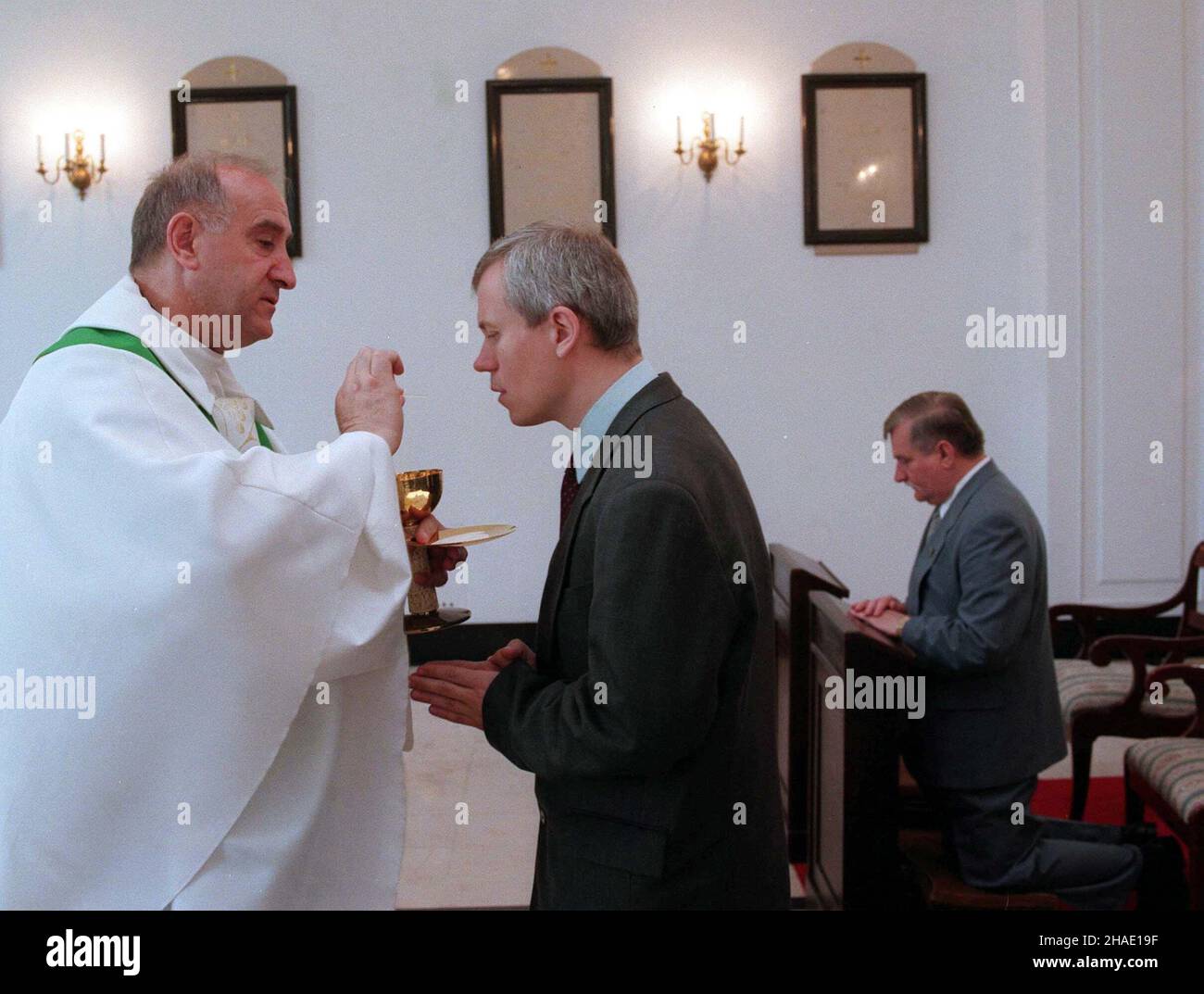 Warszawa, 20.06.1995. Spotkanie prezydenta Lecha Wa³êsy i przewodnicz¹cego KRRiTV Marka Jurka. N/z: KS. pra³at Franciszek Cybula (L) udziela komunii œwiêtej Markowi Jurkowi (C). W g³êbi klêczy Lech Wa³êsa (P). (kruu) PAP/Maciej B. Brzozowski Warschau, 20.06.1995. Polens Präsident Lech Walesa (R) und Marek Jurek (C), Leiter des Nationalen Rundfunkrates (polnischer KRRiT), in der Präsidentenkapelle während einer Heiligen Messe, die vom Präsidentenpfarrer Franciszek Cybula (L) gefeiert wurde. (kruu) PAP/Maciej B. Brzozowski Stockfoto