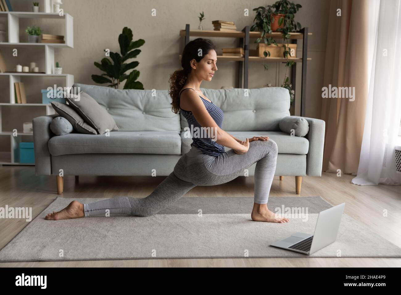 Gesunde Frau trainieren online mit Computer zu Hause Stockfoto