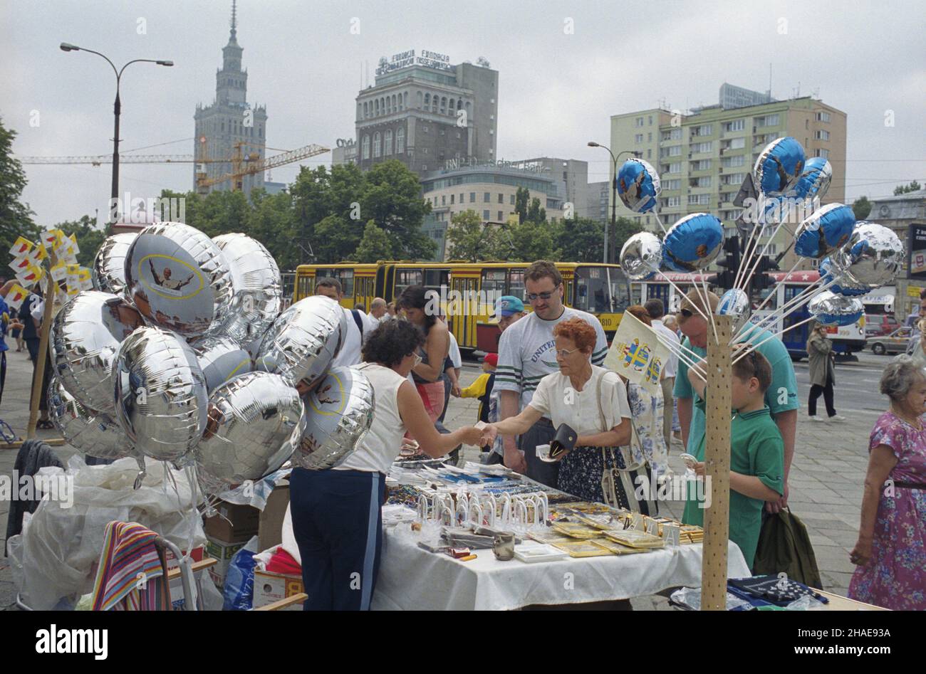 Warszawa 06,1999. VII pielgrzymka Papier¿a Jana Paw³a II do Polski. Handel pami¹tkami papieskimi w Centrum stolicy, na ul. Marsza³kowskiej. W g³êbi Pa³ac Kultury i Nauki (L), budynek Polskiej Akcyjnej Spó³ki Telefonicznej (PAST-A) (C) przy ul. Zielnej. mw PAP/Piotr Gêsicki Dok³adny dzieñ wydarzenia nieustalony. Warschau, Juni 1999. Die siebte Pilgerreise von Papst Johannes Paul II. Nach Polen. Im Bild: Händler in der Marszalkowska Straße verkaufen päpstliche Souvenirs. Im Hintergrund der Palast der Kultur und Wissenschaft (L) und das Polnische Gebäude der Gemeinsamen Telefonanlage (PAST). mw PAP/Piotr Gesicki Veranstaltungstag unbekannt Stockfoto