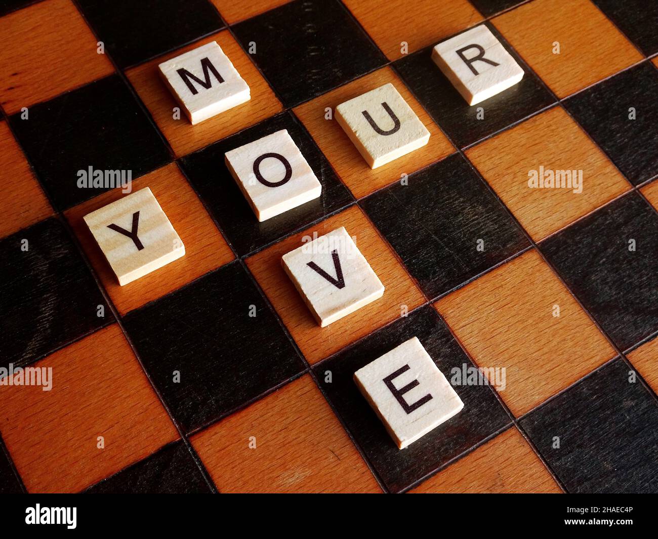 Deine Bewegung. Scrabble Buchstaben auf Holzchessboard Stockfoto