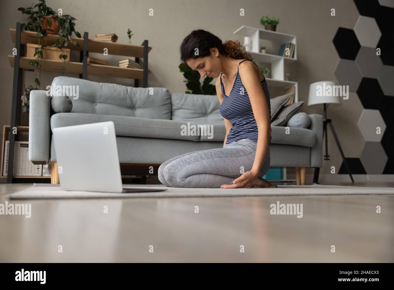 Gesunde lateinische Frau trainieren online mit Computer Stockfoto