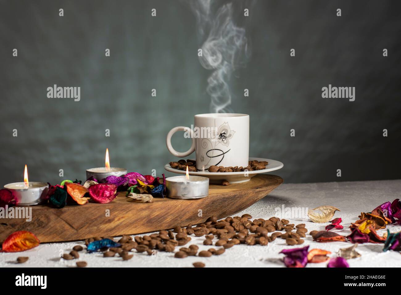 Tasse heißen türkischen Kaffee und Kerzen, getrocknete Rosenblätter auf Holztisch Stockfoto