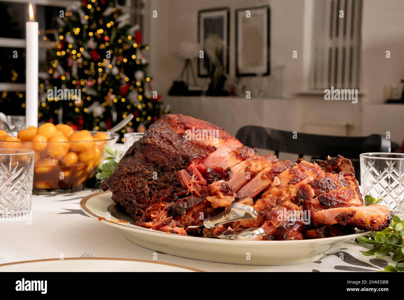 Ein traditionelles nordisches weihnachtsessen auf dem Tisch, mit braunen Kartoffeln und Fleisch in Scheiben, fertig zum Essen, heißem Dampf, der vom Steak aufsteigt Stockfoto