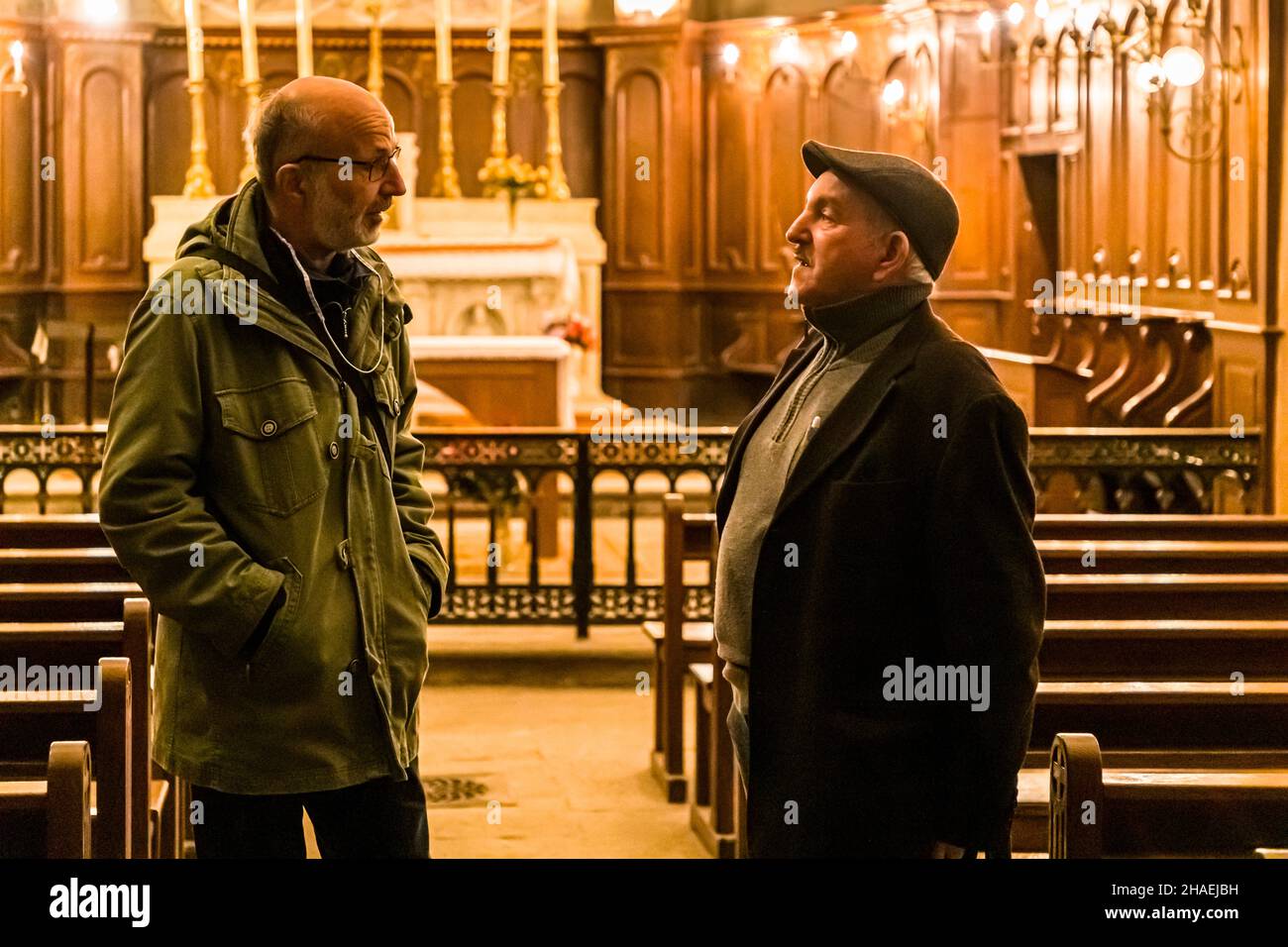 Kader Zennaf (rechts mit Spitzenkappe) ist ein Muslim und hält die Schlüssel der Kirche St. Ennemond. Seine Familie erstreckt sich über 4 Generationen. Er selbst ist der Vater von 7 Söhnen und derzeit 18 Enkelkindern. Aufgrund dieser wunderbaren Familienkonstellation freut er sich, direkt ins Paradies zu kommen. In der Kirche St. Ennemond werden jedes Jahr nur zwei Messen gesprochen. Saint-Chamond, Frankreich. Zitat: Christen, Juden und Muslime haben denselben Chef, aber unterschiedliche Abteilungsleiter Stockfoto