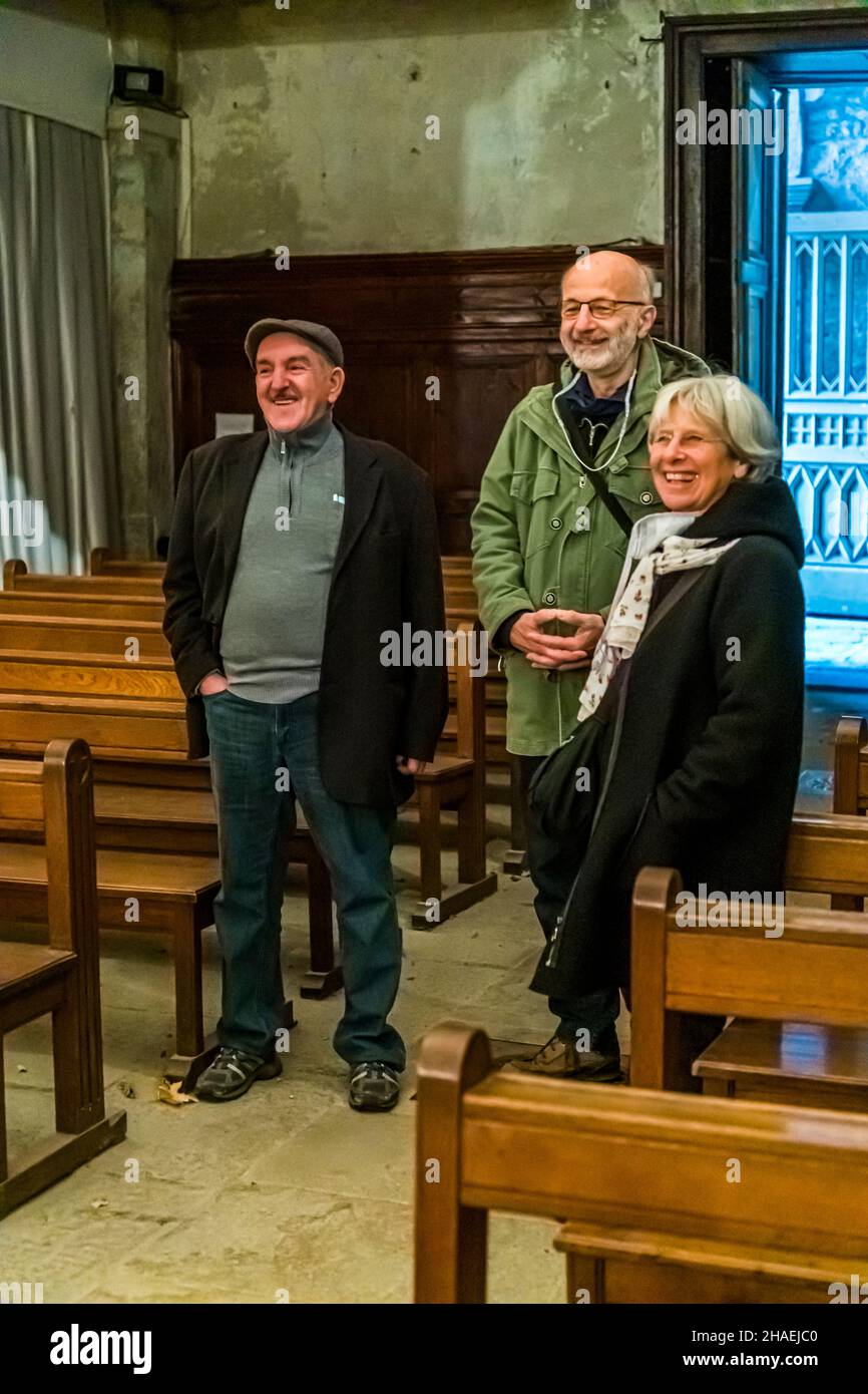 Kader Zennaf (links mit Spitzenkappe) ist ein Muslim und bewahrt die Schlüssel der Kirche St. Ennemond auf. Seine Familie erstreckt sich über 4 Generationen. Er selbst ist der Vater von 7 Söhnen und derzeit 18 Enkelkindern. Aufgrund dieser wunderbaren Familienkonstellation freut er sich, direkt ins Paradies zu kommen. In der Kirche St. Ennemond werden jedes Jahr nur zwei Messen gesprochen. Saint-Chamond, Frankreich. Zitat: Christen, Juden und Muslime haben denselben Chef, aber unterschiedliche Abteilungsleiter Stockfoto