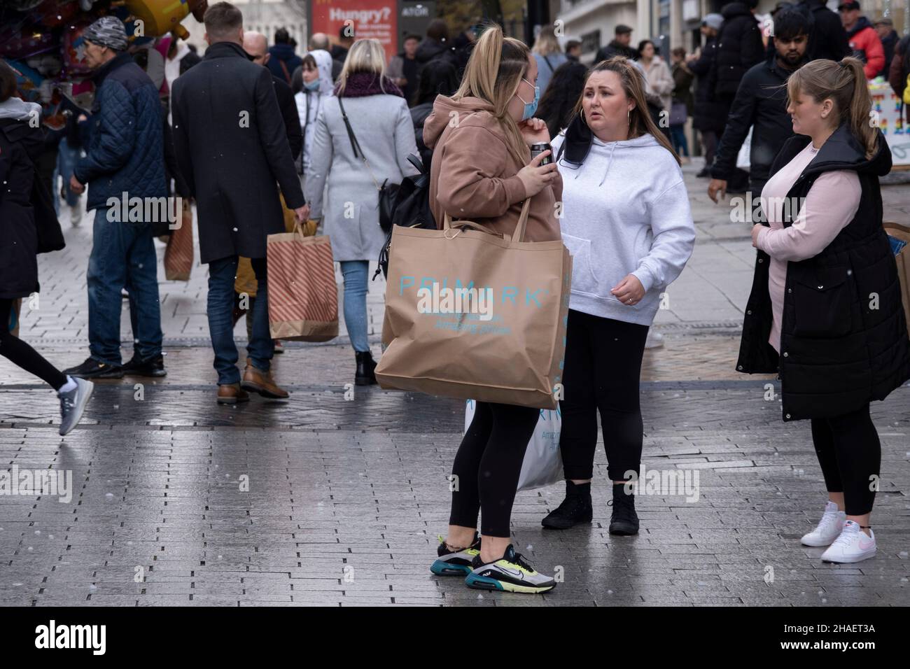 Massen von Weihnachtseinkäufern, einige mit Gesichtsmasken und andere nicht, kommen zum Bull Ring Shopping Centre, da die Entstehung der neuen Covid-19 Omicron-Variante am 12th. Dezember 2021 in Birmingham, Großbritannien, fortgesetzt wird. Die Beschränkungen sind vor etwa 2 Wochen gestiegen, wodurch Gesichtsbedeckungen in Geschäften und öffentlichen Verkehrsmitteln obligatorisch werden. Trotz der neuen Regeln trägt die Mehrheit der Menschen weder draußen in überfüllten Einkaufsvierteln noch im Einkaufszentrum Masken. Stockfoto