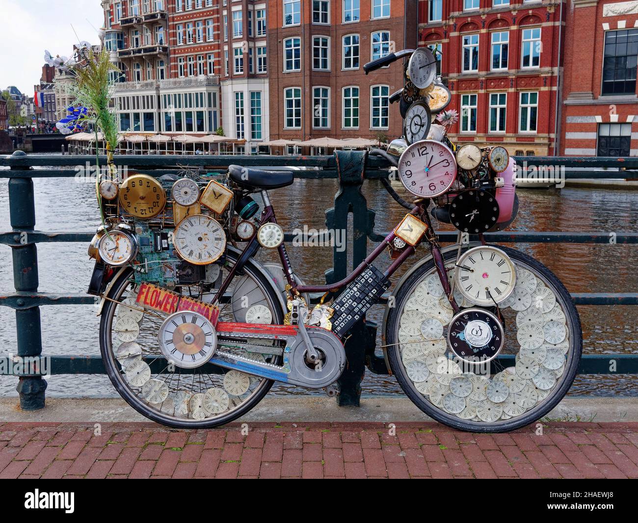 AMSTERDAM, NIEDERLANDE - MAI 2021: Fahrrad mit vielen Uhren und Zeitmessern auf einer Brücke im Stadtzentrum dekoriert Stockfoto