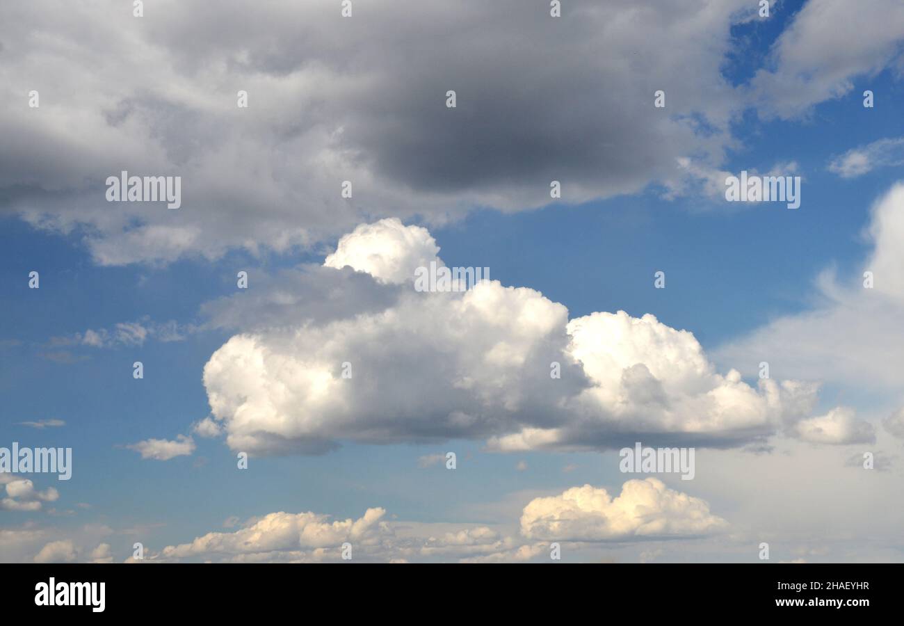 Große weiße flauschige Wolken in den tiefblauen Himmel, Sommerhimmel mit verschiedenen Wolken Tapete. Wolkenlandschaft Hintergrund Stockfoto
