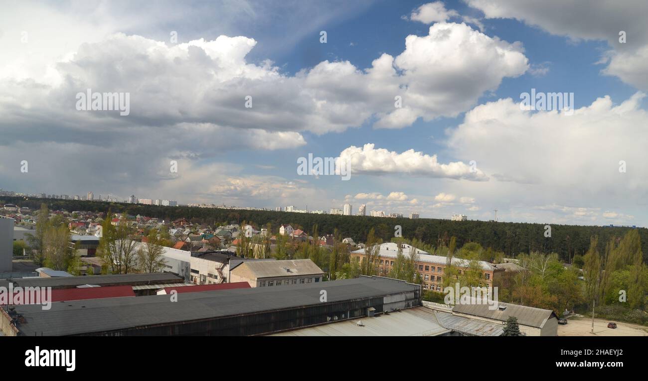 Stürmischer Himmel über Häusern, dunkle Regenwolken nähern sich. Sommerregen, Wald- und Stadtszene Stockfoto
