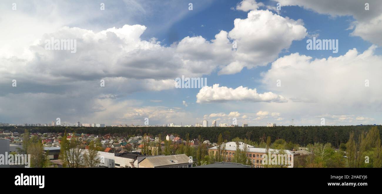 Wolken fliegen über der Stadt am tiefblauen Himmel. Wolkenbildfotografie, sommerlicher Himmel im Hintergrund Stockfoto