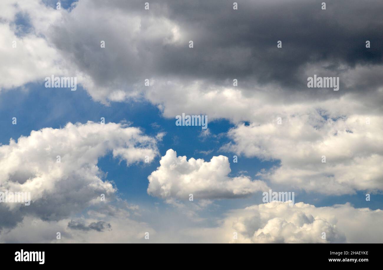 Weiße Wolke zwischen dunklen Regenwolken, natürlicher blauer Himmel Hintergrund Stockfoto